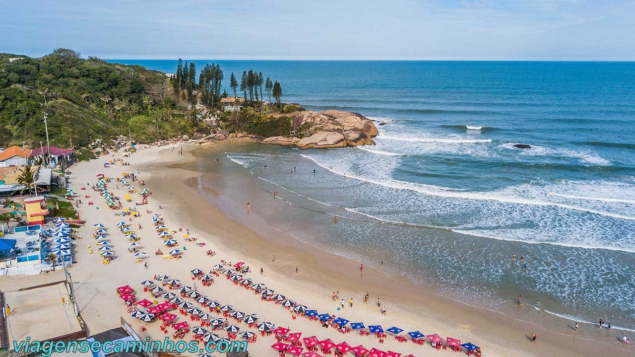 Praia da Joaquina em Florianópolis com ondas e dunas ao fundo